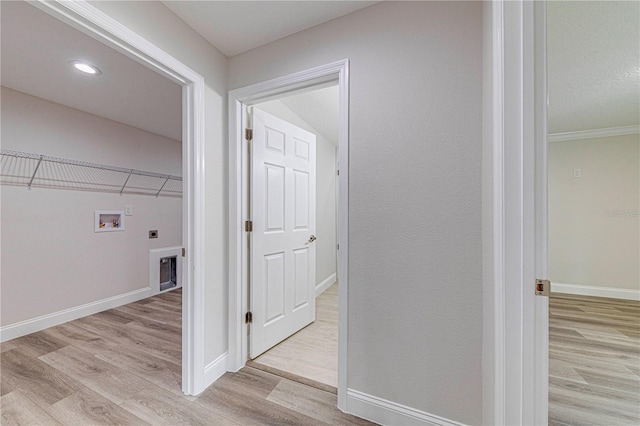 clothes washing area featuring hookup for a washing machine, light hardwood / wood-style floors, crown molding, and electric dryer hookup