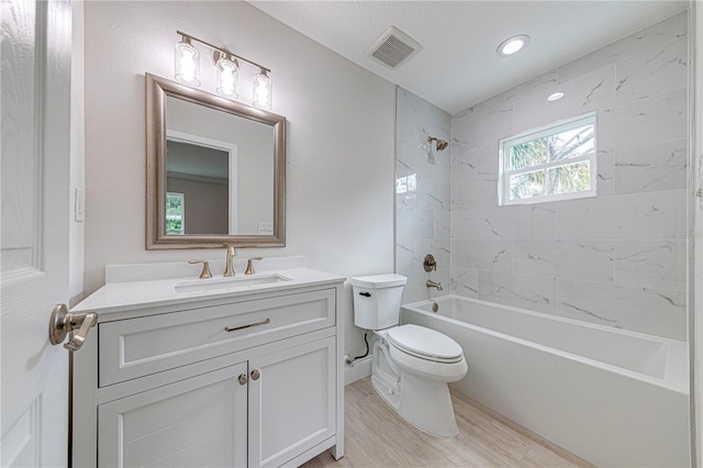 full bathroom with hardwood / wood-style flooring, vanity, toilet, and tiled shower / bath