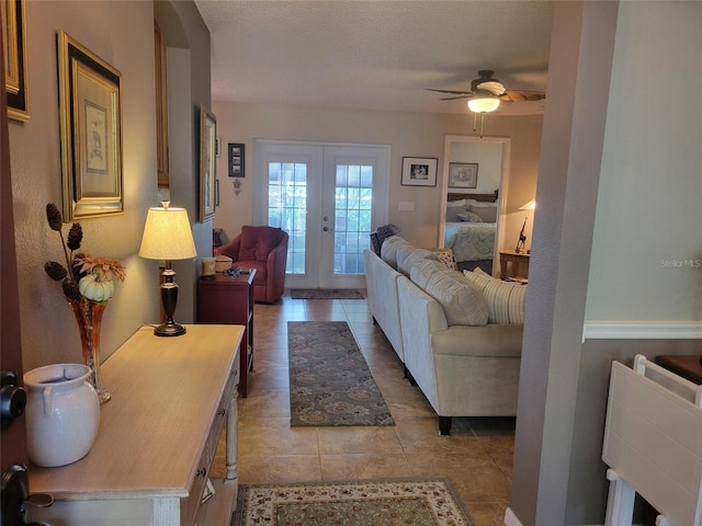 living room with french doors, a textured ceiling, ceiling fan, and light tile patterned flooring