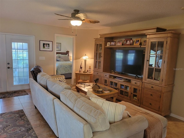 tiled living room featuring ceiling fan and a textured ceiling