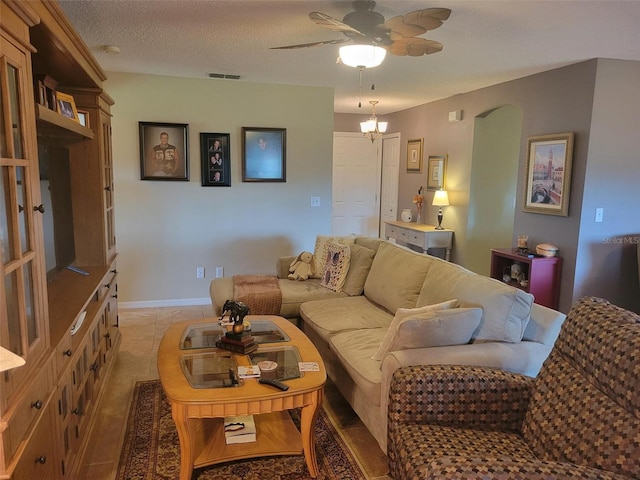 living room featuring a textured ceiling and ceiling fan with notable chandelier