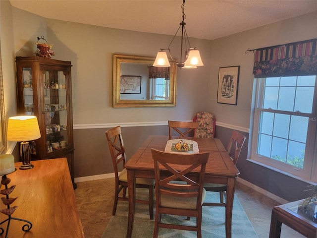 dining space with a chandelier, tile patterned flooring, and a wealth of natural light