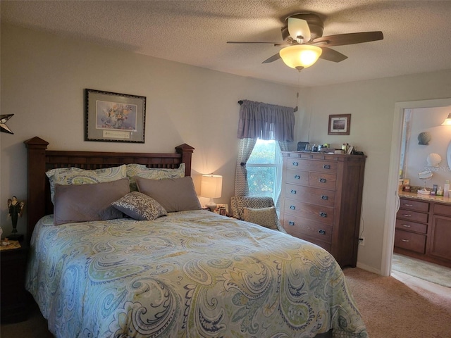 bedroom with ensuite bathroom, ceiling fan, light colored carpet, and a textured ceiling