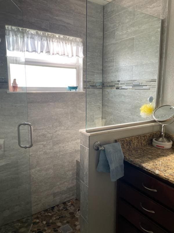 bathroom featuring vanity and an enclosed shower