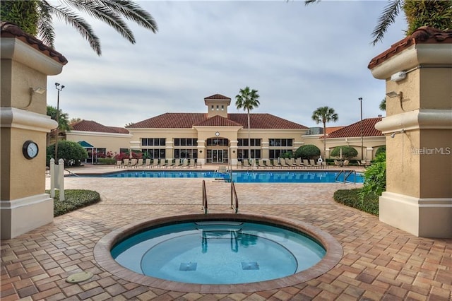 view of swimming pool with a patio and a hot tub