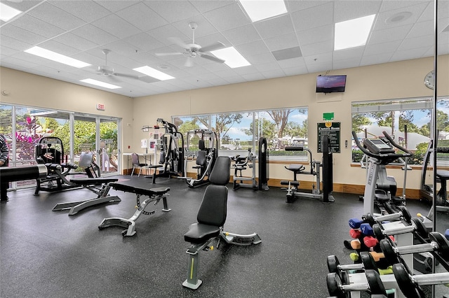 exercise room with a paneled ceiling and ceiling fan