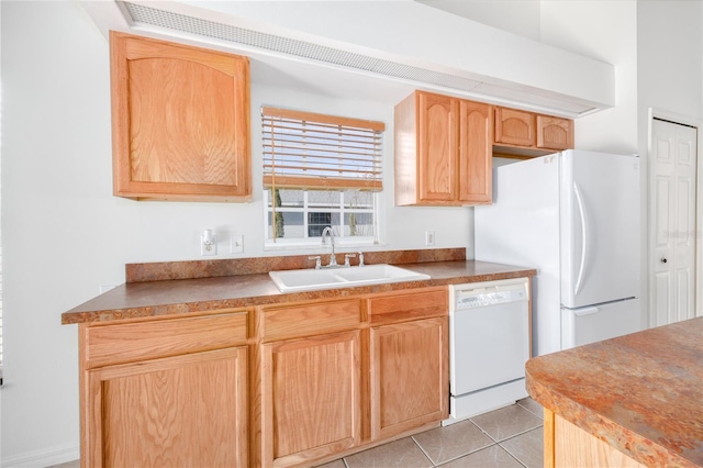 kitchen with light tile patterned flooring, light brown cabinets, white appliances, and sink