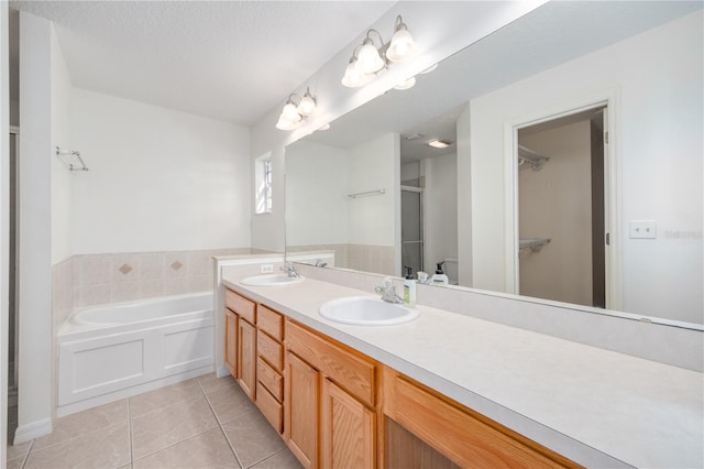 bathroom featuring a bathing tub, tile patterned flooring, vanity, and a textured ceiling