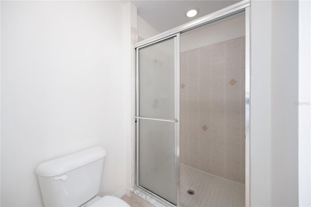 bathroom with an enclosed shower and toilet