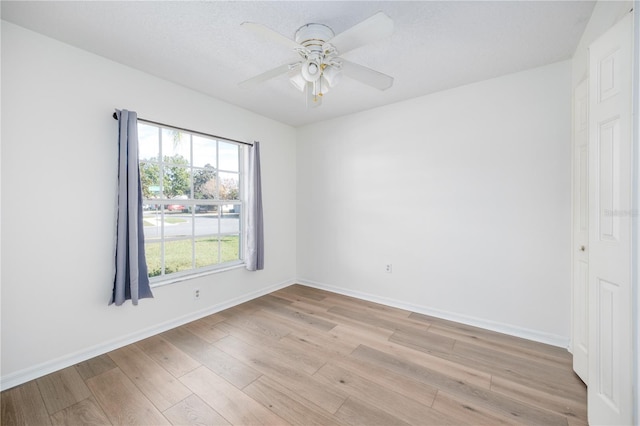 empty room featuring ceiling fan and light hardwood / wood-style flooring