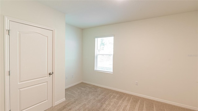 unfurnished room with light colored carpet