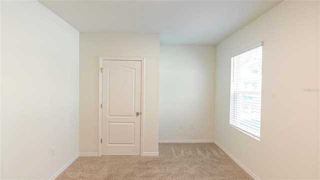 spare room featuring light colored carpet