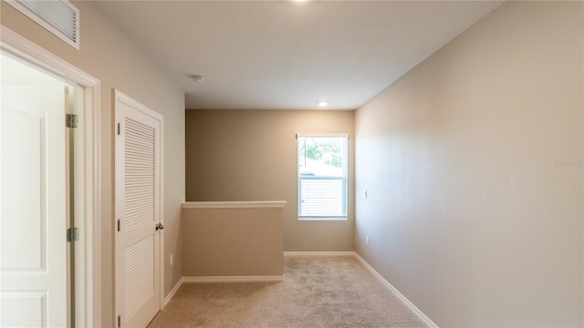 hall featuring light colored carpet