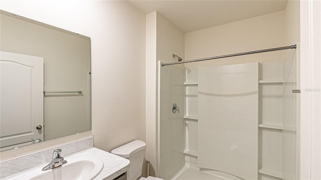 bathroom with toilet, a shower, and vanity