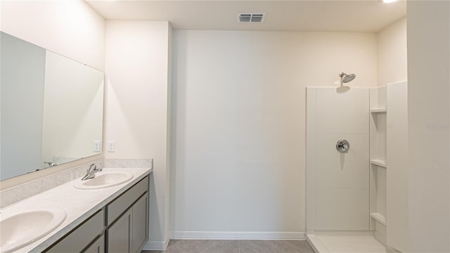 bathroom featuring tile patterned floors, vanity, and a shower