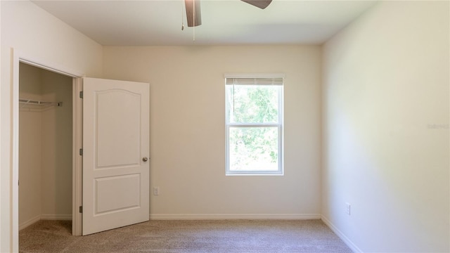 unfurnished bedroom featuring light carpet, a closet, and ceiling fan