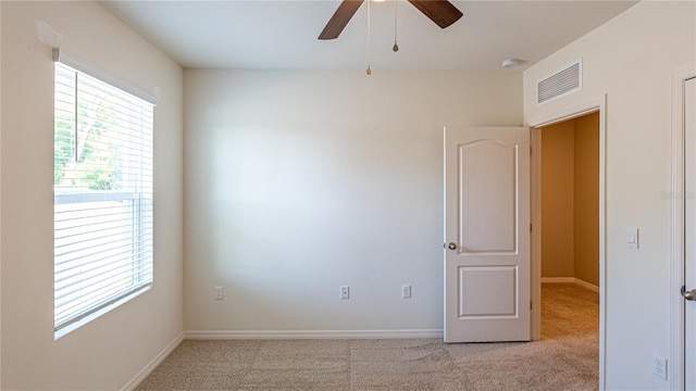 spare room featuring light carpet and ceiling fan