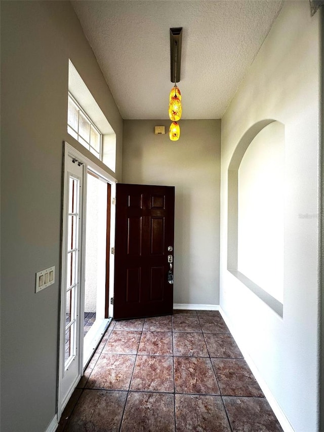 tiled foyer featuring a textured ceiling