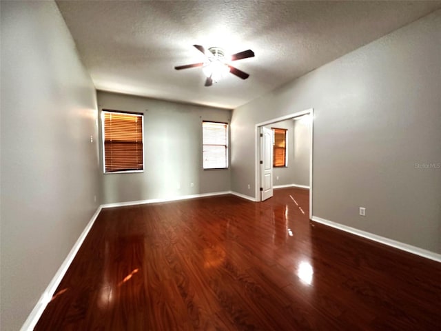 spare room with ceiling fan, dark wood-type flooring, and a textured ceiling