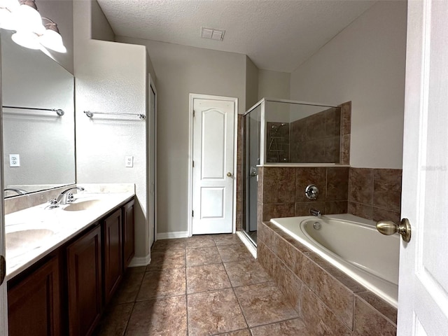 bathroom featuring vanity, tile patterned floors, a textured ceiling, and separate shower and tub