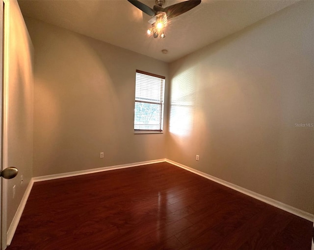 spare room with ceiling fan and dark hardwood / wood-style flooring