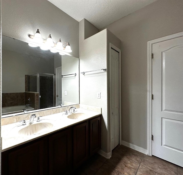 bathroom with plus walk in shower, vanity, and a textured ceiling