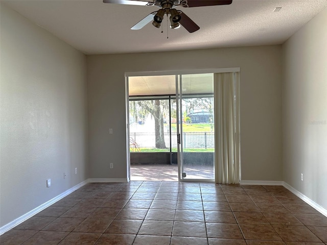 unfurnished room with dark tile patterned flooring and ceiling fan