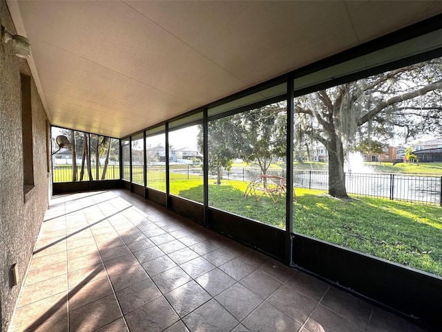 unfurnished sunroom with a water view