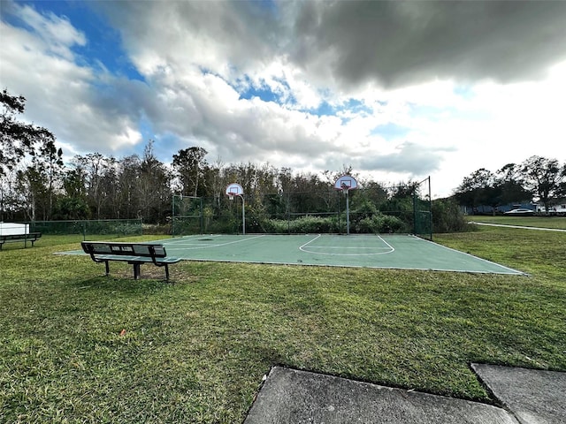 view of sport court with a lawn