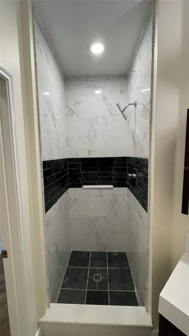 bathroom with tiled shower and vanity