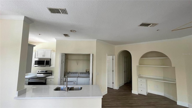 kitchen with dark wood-type flooring, separate washer and dryer, a textured ceiling, appliances with stainless steel finishes, and white cabinetry