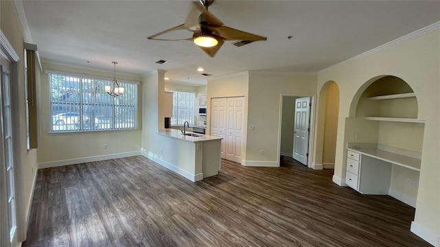 kitchen featuring sink, dark hardwood / wood-style floors, kitchen peninsula, decorative light fixtures, and ornamental molding