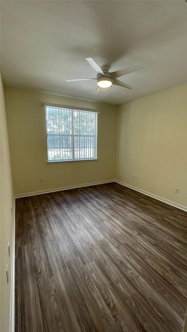 unfurnished room with dark hardwood / wood-style floors and ceiling fan