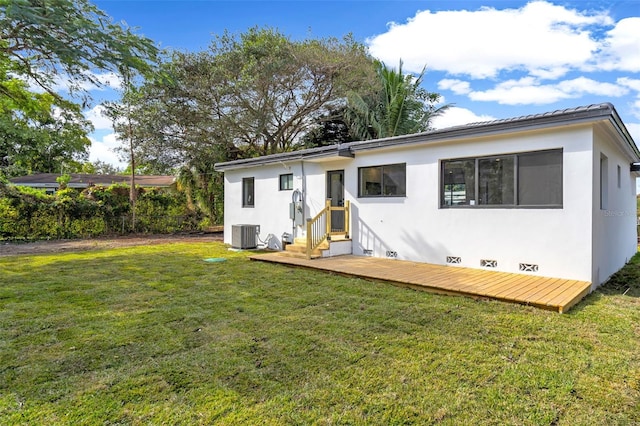 rear view of house featuring a lawn and central air condition unit