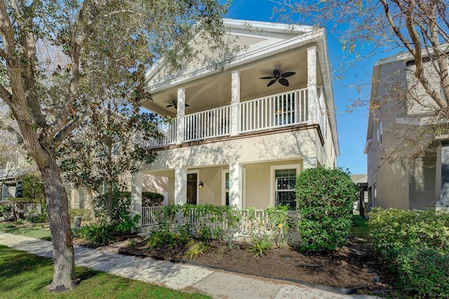 view of front of property with ceiling fan and a balcony