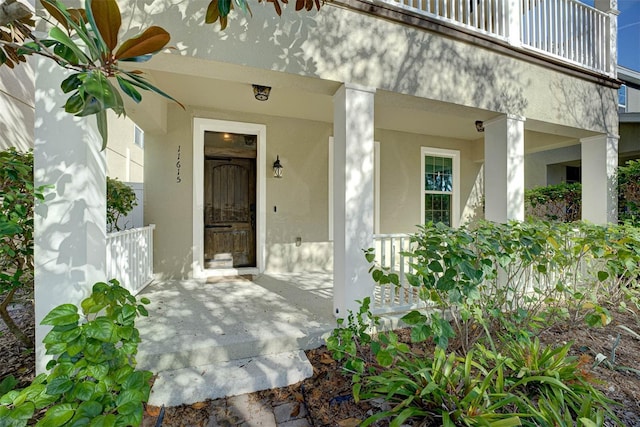 view of exterior entry featuring a balcony