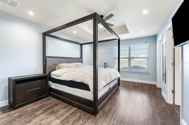 bedroom featuring ceiling fan, dark hardwood / wood-style flooring, and a textured ceiling