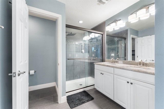 bathroom with tile patterned flooring, vanity, and walk in shower