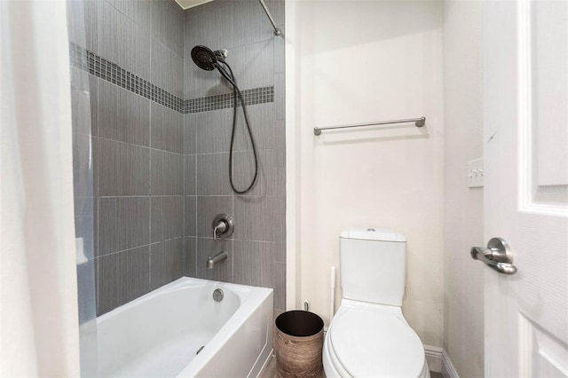 bathroom with toilet and tiled shower / bath