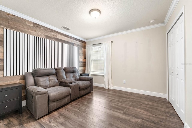 living room with a textured ceiling, dark hardwood / wood-style flooring, and crown molding