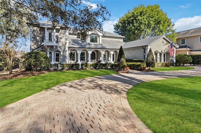 view of front of property with a balcony and a front lawn