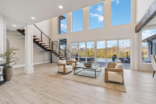 living room featuring light hardwood / wood-style floors and a towering ceiling