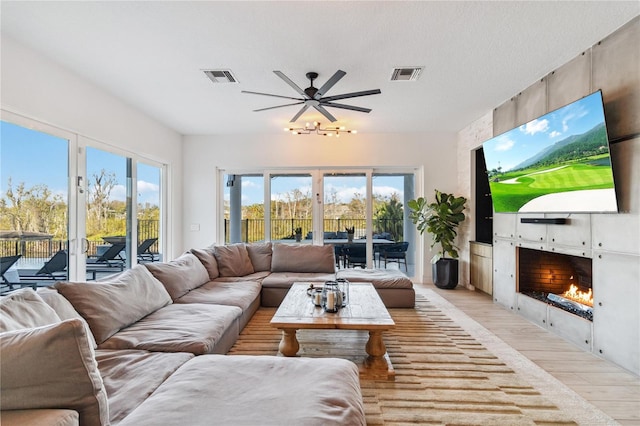 living room featuring plenty of natural light, light wood-type flooring, and a fireplace