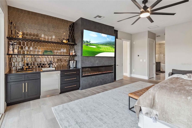 bar with ceiling fan, refrigerator, and light hardwood / wood-style flooring