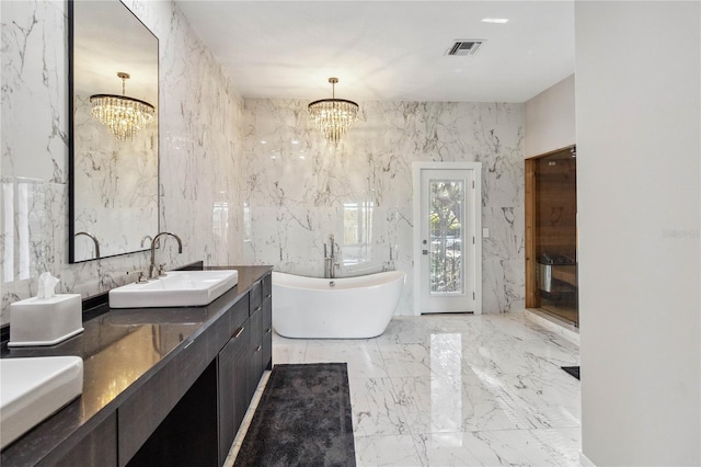 bathroom featuring vanity, an inviting chandelier, tile walls, and a bathing tub