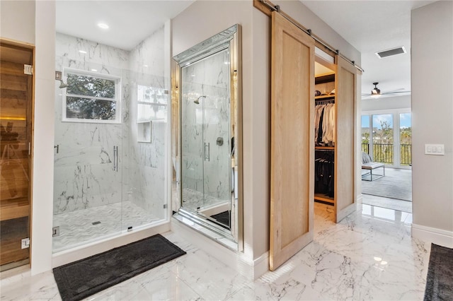 bathroom with a shower with shower door and ceiling fan