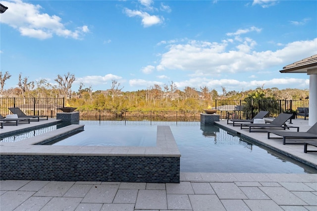 view of pool featuring a patio area and a water view