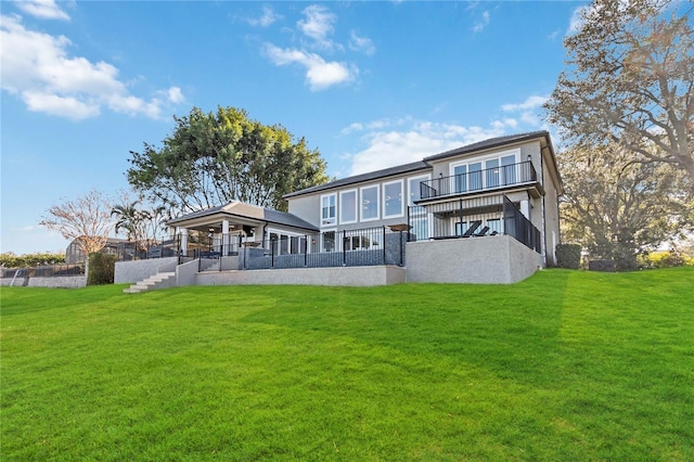 rear view of house featuring a lawn and a balcony