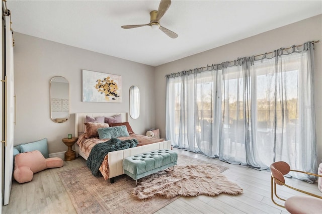 bedroom with ceiling fan, access to outside, and wood-type flooring