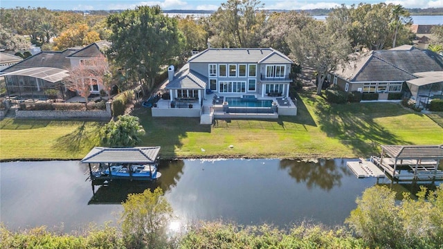 back of house featuring a yard, a water view, and a patio area